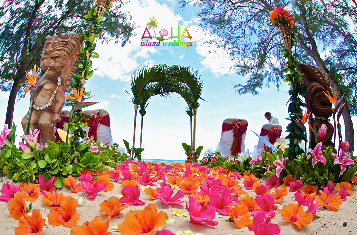 Hawaii beach wedding with tiki men pre wedding with orange and pink Hawaiian tropical flowers